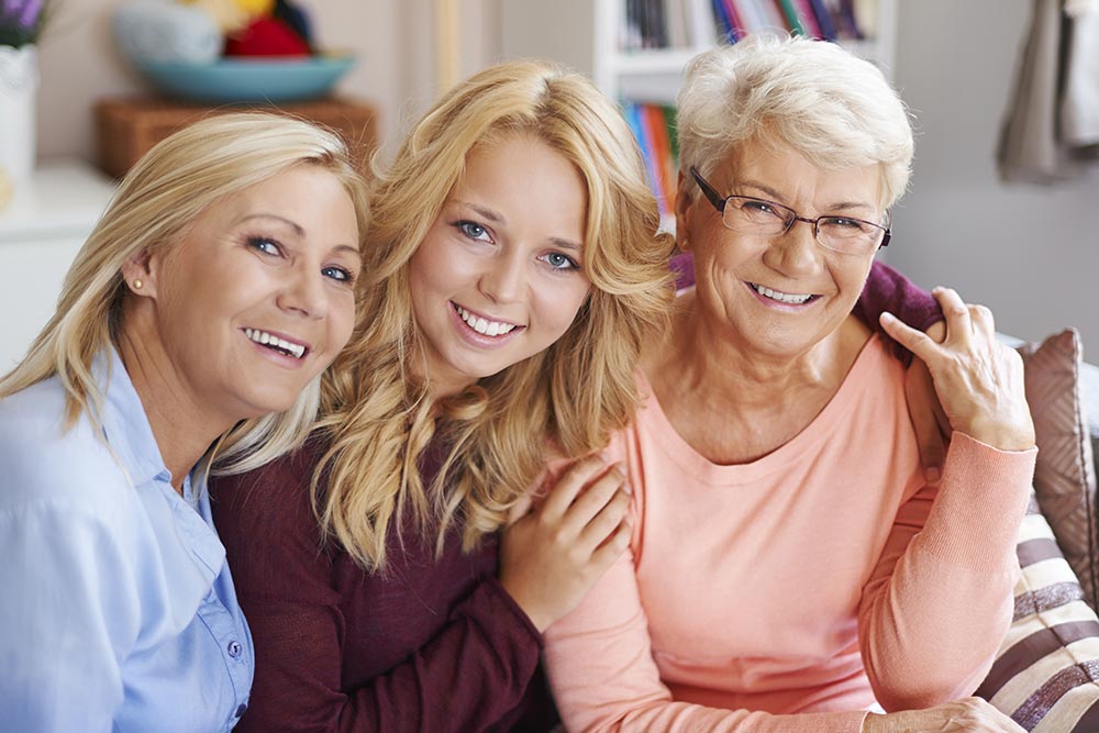 Trois générations de femmes souriantes et complices, symbolisant la communauté bienveillante de Femmes en Harmonie, un espace d'échange et de soutien pour les femmes de 45 ans et plus, où chacune peut partager ses expériences, ses défis et ses réussites.