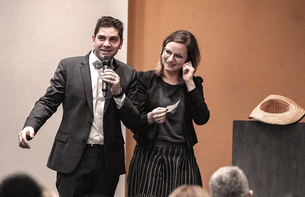 Sabrina et Nicolas sur scène micros en main présentant leur nouveau projet. Ils ont surmonté l'adversité avec courage et résilience pour donner naissance à un nouveau projet inspirant.