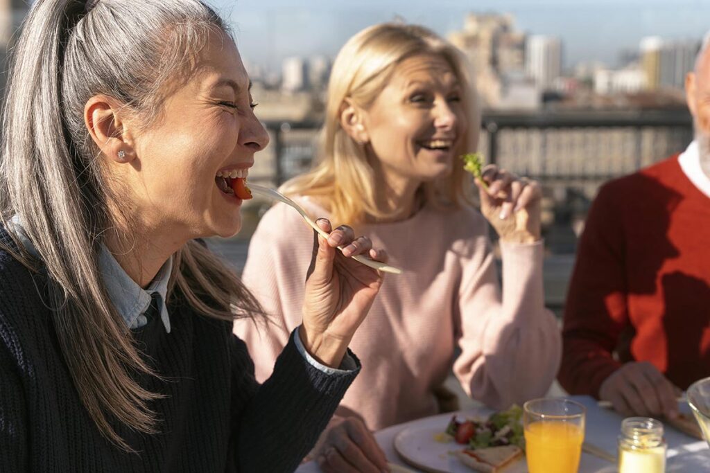 Sur la terrasse ensoleillée d'un restaurant, un groupe de femmes rayonne de bonne humeur et d'épanouissement, partageant un moment délicieux ensemble. Dans cette scène animée par la complicité et la joie, ces femmes nous rappellent l'importance de cultiver des relations enrichissantes et de savourer chaque instant.