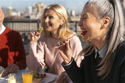 Des femmes déjeunent à la terrasse d'un restaurant, savourant un moment agréable et profitant pleinement du moment présent. Leur convivialité et leur joie de vivre illustrent l'importance de cultiver une attitude positive et d'apprécier les petits plaisirs de la vie.