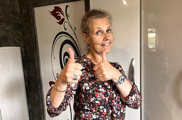 Béa, fondatrice de Femmes en Harmonie, rayonnante avec un sourire inspirant et les deux pouces en avant, encourage sur l'importance de consommer des aliments riches en protéines pour une santé optimale après 45 ans.