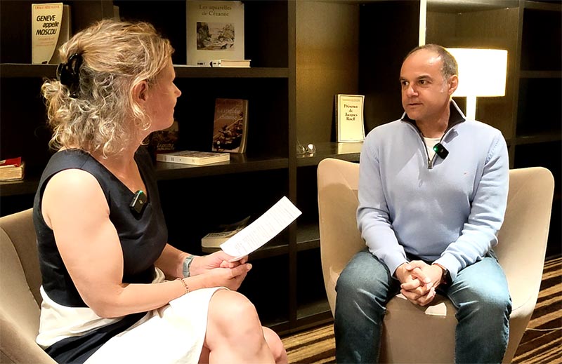 Échange autour des bienfaits de l'ostéopathie entre Béa et Philippe Thauvoye, dans l'ambiance cosy d'un salon d'hôtel.