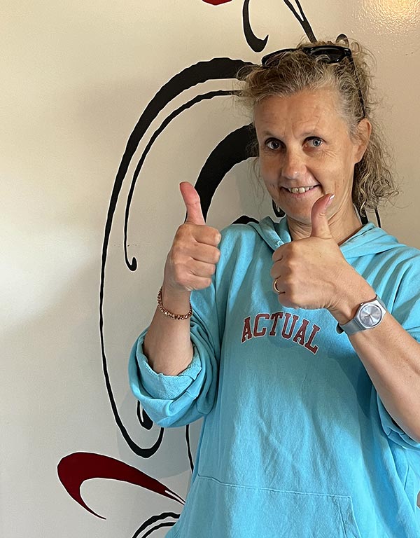 Béa, créatrice de Femmes en Harmonie, souriante et levant les pouces, symbolisant le message d’encouragement pour un bien-être global à travers une alimentation saine et un mode de vie équilibré.
