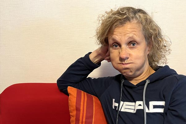 Béa, la créatrice de Femmes en Harmonie, grimaçant, illustrant la frustration et l'épuisement liés aux symptômes de la ménopause, notamment les bouffées de chaleur.