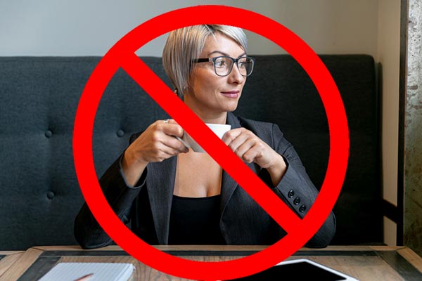 Femme avec des lunettes buvant un café, illustrant l'effet de la caféine sur les bouffées de chaleur, un symptôme de la ménopause.