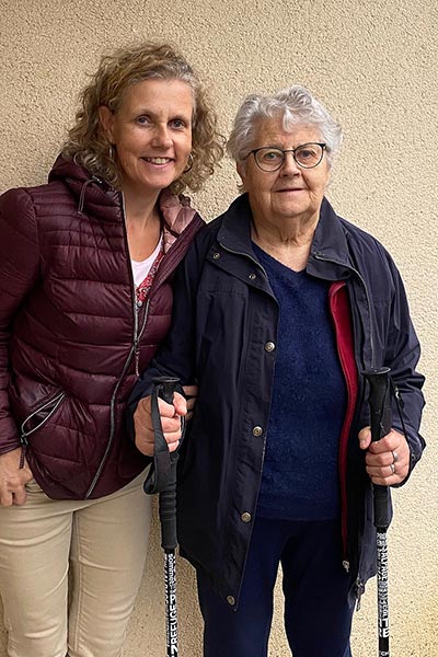 Béa, fondatrice de Femmes en Harmonie, pose avec sa maman de 85 ans, tenant des bâtons de marche nordique. Cette photo illustre que la marche nordique est une activité bénéfique pour tous les âges, favorisant la santé, l'équilibre et le bien-être.