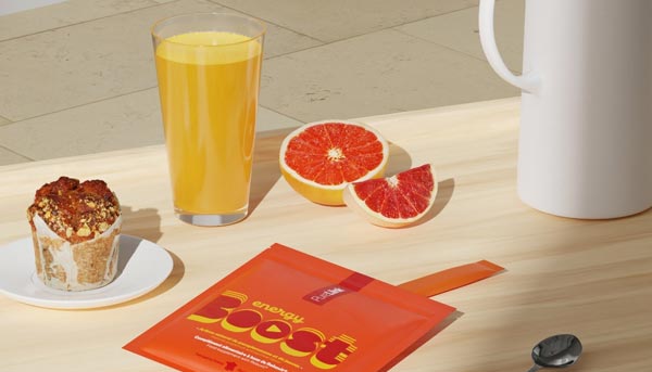 Complément alimentaire Energy Boost de PureLiink présenté sur une table avec un jus d’orange frais, un pamplemousse coupé et un muffin, illustrant les bienfaits des aliments énergétiques pour soutenir énergie et vitalité au quotidien.