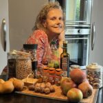 Béa, créatrice de Femmes en Harmonie, se tient dans sa cuisine entourée d'ingrédients sains et nutritifs, illustrant l'importance de cuisiner des plats réconfortants. Cette image souligne l'utilisation de produits frais et de qualité pour préparer des repas équilibrés et savoureux.