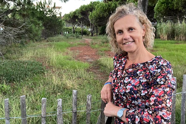 Béa, souriante en pleine campagne, illustre la confiance retrouvée après avoir surmonté les défis de la prise de poids avec l'âge, symbolisant l’équilibre et le bien-être.