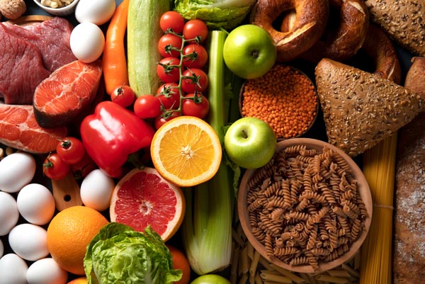 Un ensemble d'aliments sains et équilibrés, incluant des légumes, fruits, protéines maigres et céréales complètes, illustrant l'importance d'une alimentation nutritive.