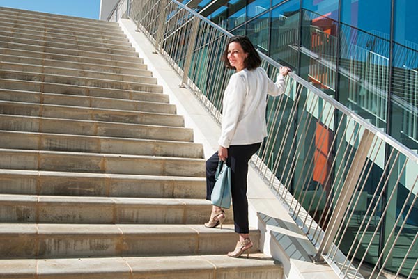 Femme montant les escaliers, symbolisant l'intégration de plus de mouvement dans le quotidien pour mieux gérer la prise de poids avec l'âge, même avec un emploi du temps chargé.