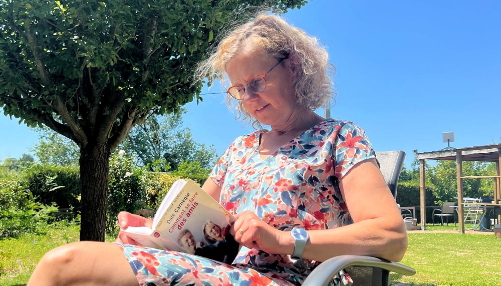 Béa, fondatrice de Femmes en Harmonie, lisant un livre inspirant dans le jardin. Pourquoi lire ? Pour bénéficier de tous les bienfaits de la lecture et notamment développer l’empathie et l’ouverture d’esprit.