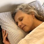 Moi, dormant profondemment dans mon lit. Cette image souligne l'importance du sommeil pour la santé physique et mentale