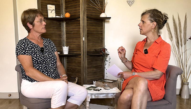 Béa, fondatrice de Femmes en Harmonie, en conversation avec Laurence Voisin, instructrice certifiée en méditation de pleine conscience. Béa est assise en face de Laurence dans un cadre chaleureux et apaisant, entourées d’éléments de décoration naturelle comme des plantes, des livres et des objets zen. 