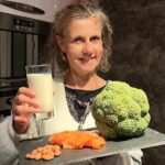Béa, fondatrice de Femmes en Harmonie, dans sa cuisine présente sur une ardoise différentes sources de calcium essentielles pour des os solides : lait, brocoli, saumon et amandes.