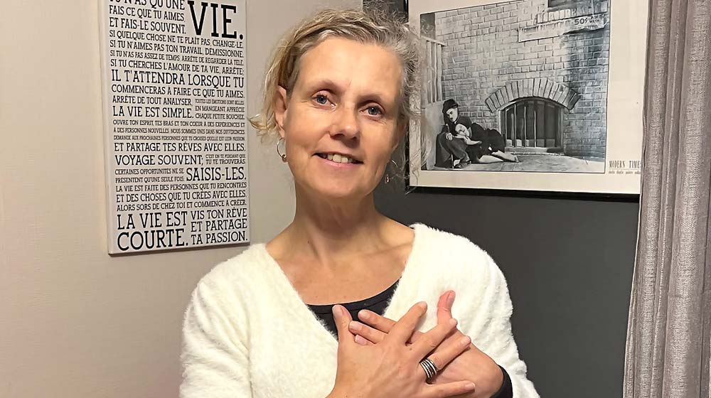 Béa, fondatrice de Femmes en Harmonie, les mains sur le cœur, incarne l’importance de pratiquer la bienveillance envers soi-même au quotidien. Ce geste simple illustre un acte d’amour et de respect pour soi, essentiel pour cultiver la sérénité et l’épanouissement personnel.