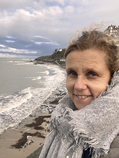 Béa, fondatrice de Femmes en Harmonie, souriante en bord de mer, symbolisant la sérénité et la confiance dans le fait de prendre de l'âge avec un état d'esprit positif.