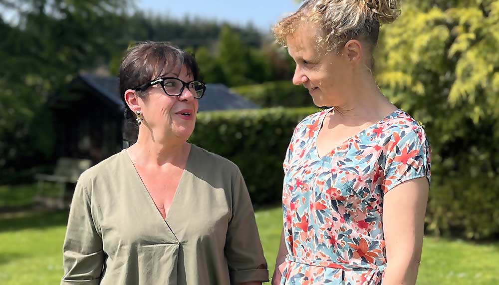Béa, fondatrice de Femmes en Harmonie, et Françoise, 71 ans, échangent avec le sourire dans son jardin ensoleillé. Une image inspirante qui illustre qu’il est possible de retrouver sa vitalité et sa joie à tout âge grâce au mouvement, à une alimentation saine et à une meilleure écoute de soi.