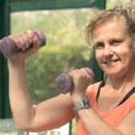 Béa, fondatrice de Femmes en Harmonie, en pleine séance de musculation pour les femmes après 50 ans avec des haltères légers.