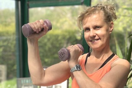 Béa, fondatrice de Femmes en Harmonie, en pleine séance de musculation pour les femmes après 50 ans avec des haltères légers.