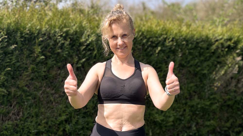 Béa, fondatrice de Femmes en Harmonie, souriante en tenue de sport dans son jardin, pouce levé, incarnant la fierté et les bienfaits d’un programme de musculation adapté aux femmes après 50 ans : énergie, confiance, autonomie et équilibre corporel au quotidien.